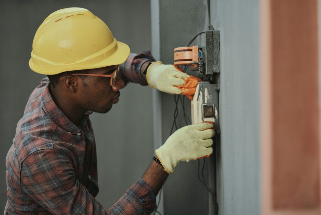 Professional electrician installing wiring representing Reliant Electrical Inc.